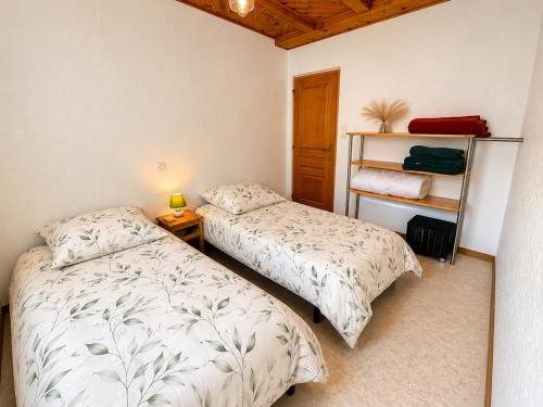 a bedroom with two beds and a book shelf at Gîte Arnica in Soultzeren