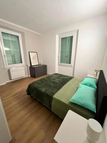 a bedroom with a large bed and two windows at Urban Apartments RE in Reggio Emilia