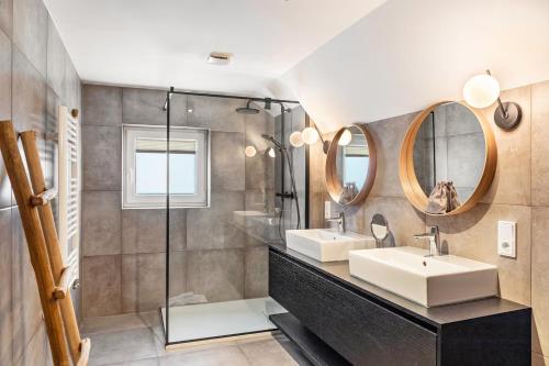 a bathroom with two sinks and a mirror at Alpin Haus Berwang in Berwang