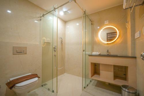 a bathroom with a glass shower and a toilet at Tiger Hill Hotel & Suites in Kalpetta
