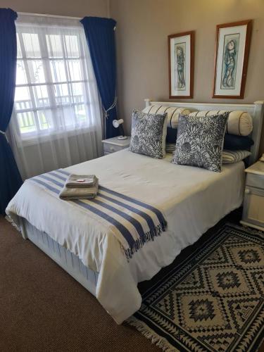 a bedroom with a large bed with blue curtains at The Blue Swallow in Kaapsehoop