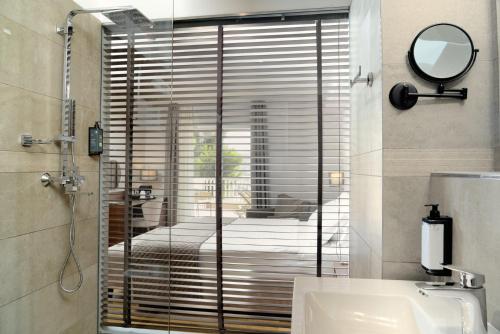 ein Badezimmer mit Dusche, Waschbecken und Spiegel in der Unterkunft Hotel Marina in Izola
