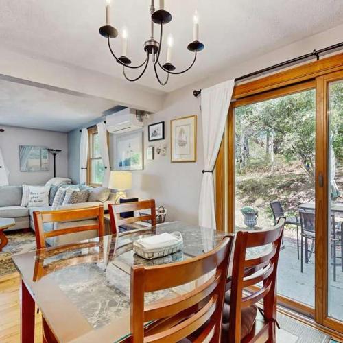 a dining room with a glass table and chairs at Bay Pointe Bungalow in East Falmouth