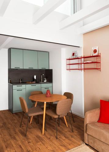 a kitchen and dining room with a table and chairs at Limehome Basel Town Hall in Basel