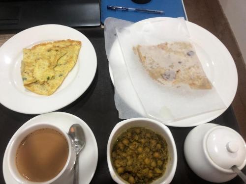 a table with three plates of food and a cup of coffee at Emporia Hotel & Suites in Lahore