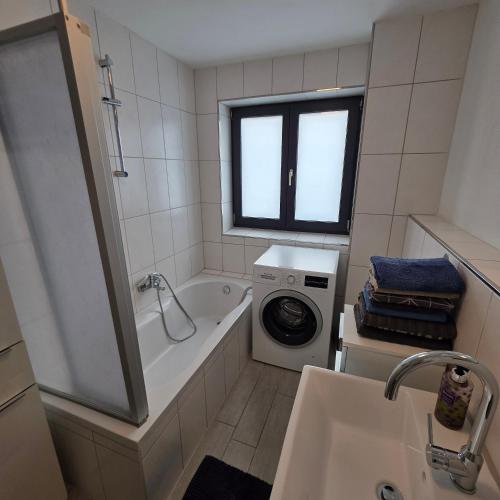 a white bathroom with a washing machine and a sink at ALLGÄU SONNENSEITE am ALPSEE -BERGE-SKI in Immenstadt im Allgäu