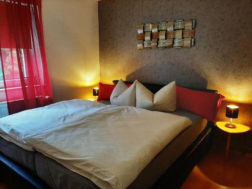 a bedroom with a large bed with red and white pillows at Eigentumswohnung Nähe See in Pirna