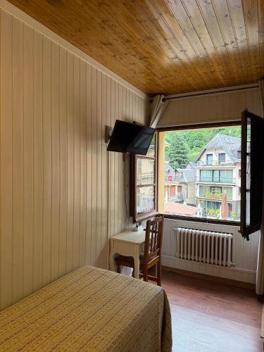 a bedroom with a bed and a window and a table at Hotel Europa Les by Dynamic Hotels in Les
