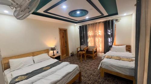 a bedroom with two beds and a blue ceiling at cloudrestskardu in Skardu