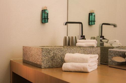 a bathroom with a sink with two mirrors and towels at Schloss Hohenkammer in Hohenkammer