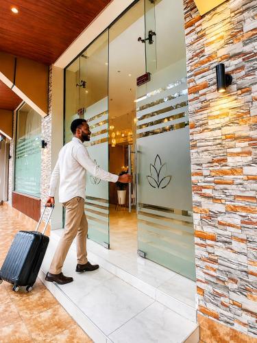 a man walking into a building with a suitcase at Magnolia Suites B&B in Dar es Salaam