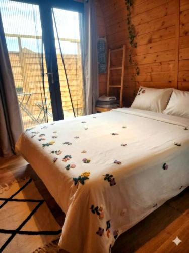 a bedroom with a bed with flowers on it at L'éco-maison tout confort in Puisserguier