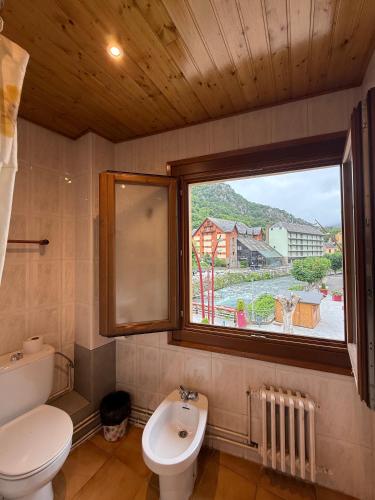a bathroom with a toilet sink and a window at Hotel Europa Les by Dynamic Hotels in Les