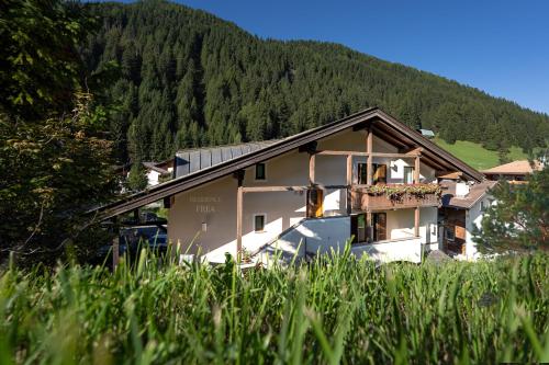 a house with a mountain in the background at Residence Frea in Selva di Val Gardena