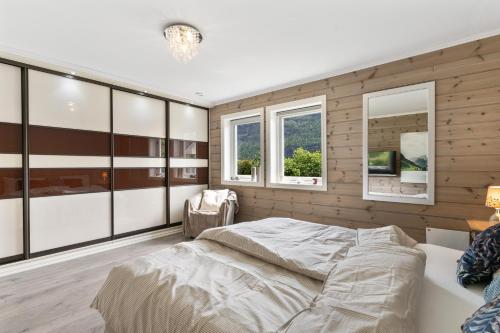 a bedroom with a large bed and two windows at Hus i Stryn med utsikt in Stryn