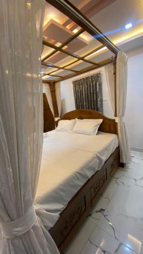 a canopy bed with white sheets and pillows at Vihari Luxury Resort in Alamanda