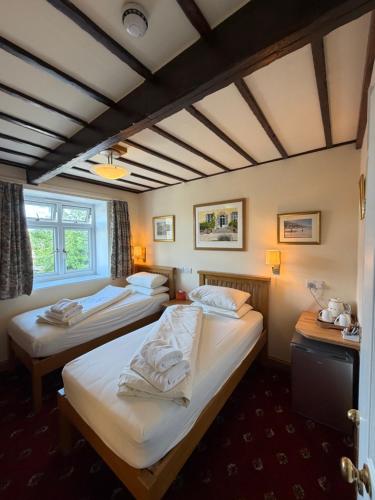 a room with two beds and a window at Oakwood Bed and Breakfast Heathrow in Hillingdon