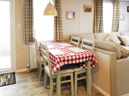 a living room with a table and a couch at Windy Roost Lodge in Tydd Saint Giles