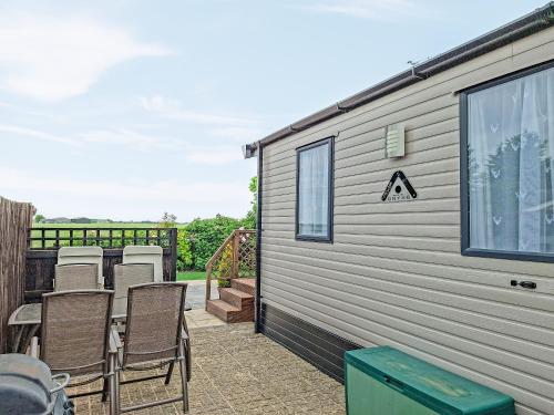 a patio with chairs and a building at Windy Roost Lodge in Tydd Saint Giles