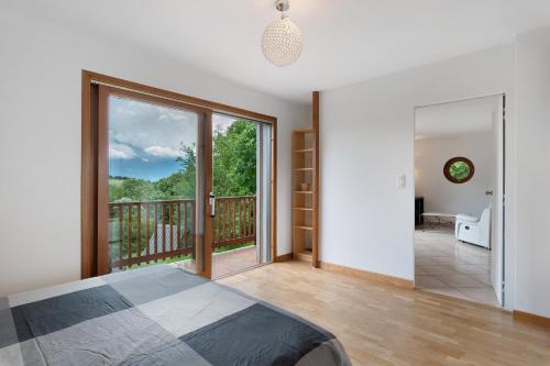 a bedroom with a bed and a balcony at Duplex la source Amelie in Saint-Pancrasse