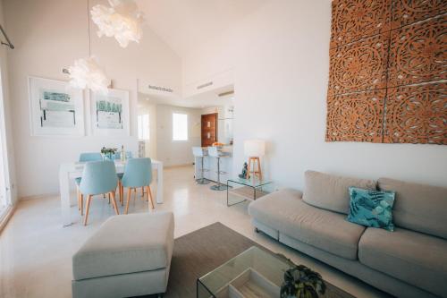 a living room with a couch and a table at Frontline Golf Penthouse Lagoon & SPA – EHHouse in Estepona