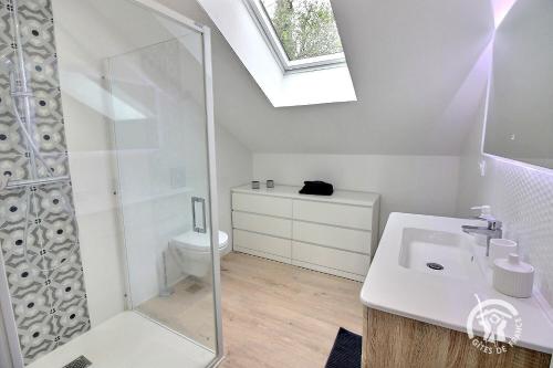 a white bathroom with a sink and a shower at Ty jaudy in Trédarzec