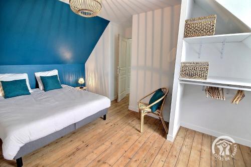 a bedroom with a bed and a blue wall at Ty jaudy in Trédarzec