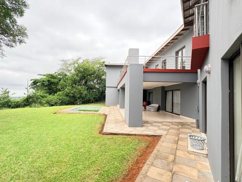 a house with a green lawn in front of it at Mabee's Place in Durban