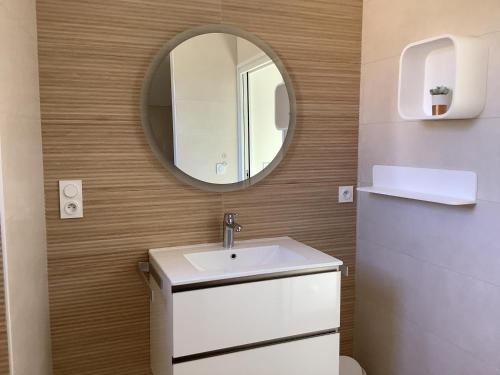 a bathroom with a sink and a mirror at La maisonnette de colette in Chastel-Nouvel