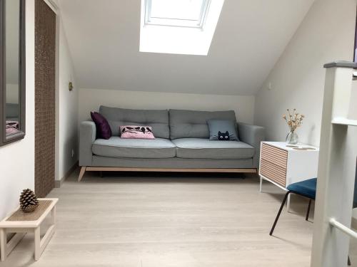 a living room with a couch and a window at La maisonnette de colette in Chastel-Nouvel
