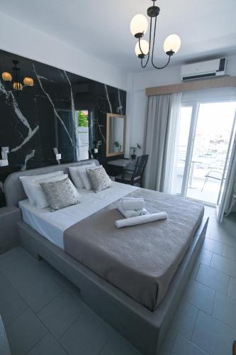 a bedroom with a large bed with a black wall at Astri Hotel in Neos Marmaras