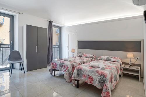 a bedroom with two beds and a table and a chair at Affitta Camere Novara in Novara