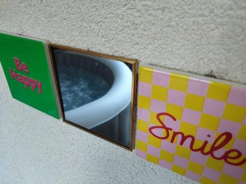 a small window in a wall with a smile sign at Maisonnette avec Jardin, Piscine, Netflix in Vichy