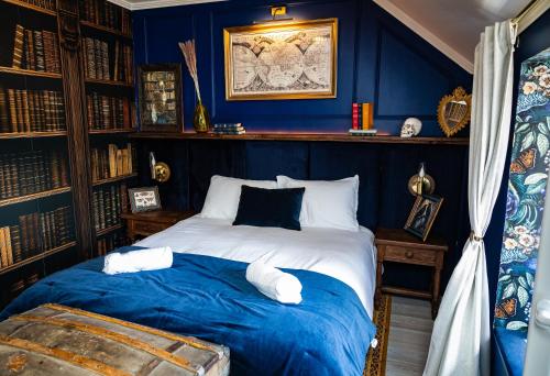 a bedroom with blue walls and a bed with pillows at Le refuge des explorateurs - chasse au trésor in La Flèche