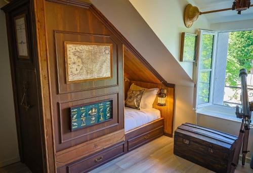a bedroom with a bed in a room with a window at Le refuge des explorateurs - chasse au trésor in La Flèche