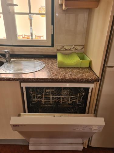 a kitchen counter with a dishwasher with a green box at Dunas Rest in Odemira