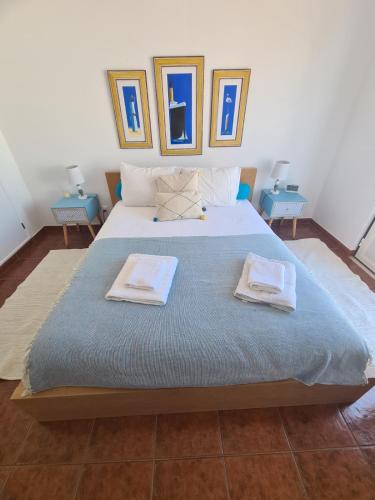 a bedroom with a large bed with two towels on it at Dunas Rest in Odemira