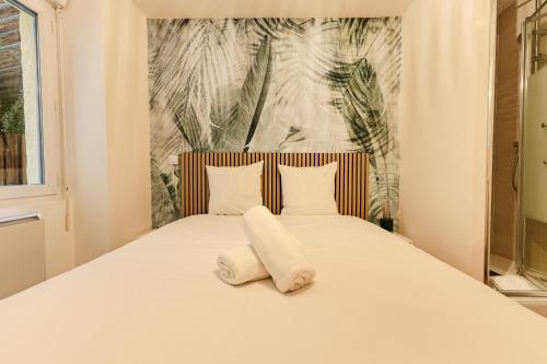 a bed with two towels sitting on top of it at La Cave Voutée - Home Cinema in Valence