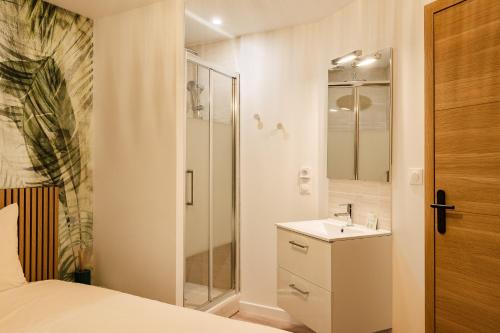 a white bathroom with a sink and a shower at La Cave Voutée - Home Cinema in Valence
