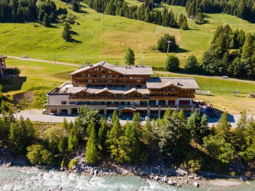an aerial view of a large building next to a river at Hôtel Saint Charles Val Cenis in Lanslebourg-Mont-Cenis