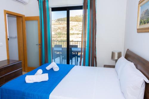a bedroom with a bed with towels on it at Marsalforn Panorama Penthouse in Marsalforn