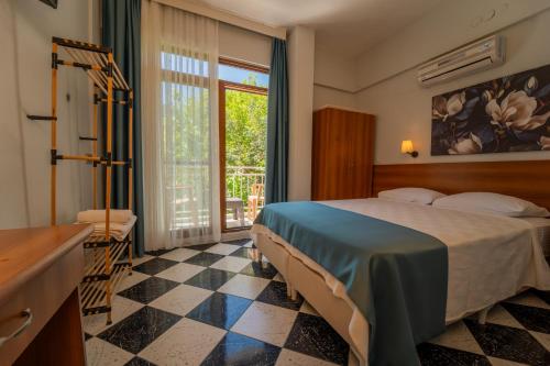 a hotel room with a bed and a window at The Turunç INN Otel in Turunç
