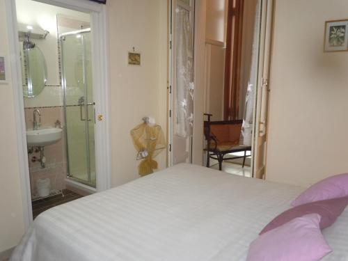 Un dormitorio con una cama y un baño con lavabo. en Da Agnese Locazioni brevi, en Cagliari