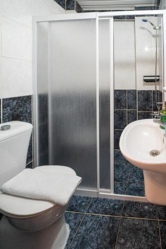 a bathroom with a shower and a toilet and a sink at The Turunç INN Otel in Turunç