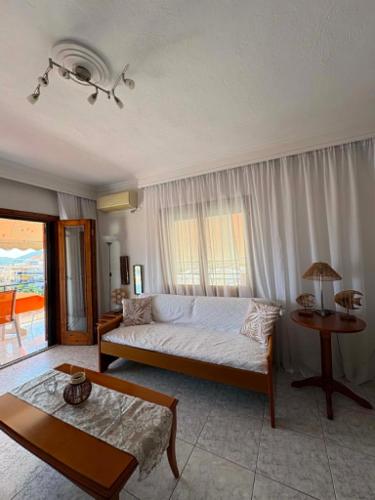a living room with a bed and a table at Thalia Sea View Apartment in Nea Peramos