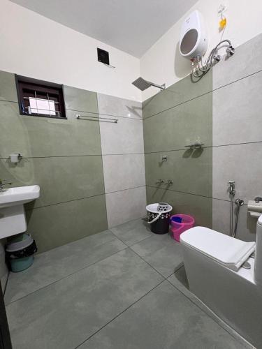 a bathroom with a shower and a toilet and a sink at Havens Nature Homestay in Ambalavayal
