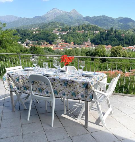 a table with chairs and plates and glasses on it at Appartamento Ai Rododendri in Pray