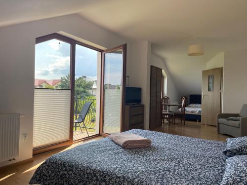 a bedroom with a bed and a view of a balcony at Gregorek in Ostrowo