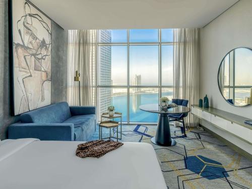 a hotel room with a bed and a large window at Pullman Sharjah in Sharjah