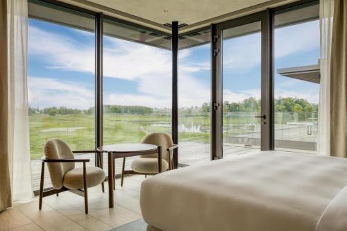 a bedroom with a bed and a large window at Radisson Collection The National Hotel, Brussels in Zaventem